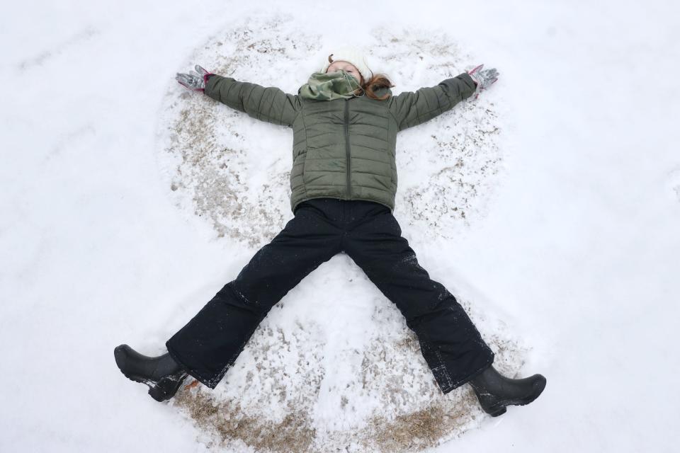 Evaline McKee, 9, makes a snow angel at Overton Park as below-freezing temperatures and snow flurries hit Memphis on  Feb. 14, 2021.