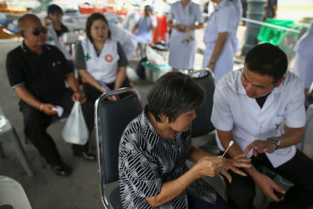 A mourner receives help from rescue teams as she waits to pay her respects to Thailand's late King Bhumibol Adulyadej at the Grand Palace in Bangkok, Thailand, October 15, 2016. REUTERS/Athit Perawongmetha