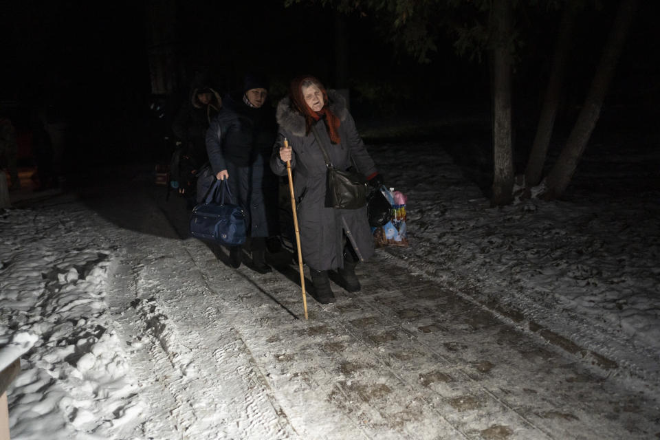 Women carry their luggage after taking a bus ride after crossing the border with Russia in the Sumy region of Ukraine, Wednesday, Nov. 22, 2023. An average of 80-120 people return daily to Ukraine from territories held by Russia through an unofficial crossing point between the two countries amid a brutal war. Most choose this challenging path, even in freezing temperatures, to escape Russian occupation and reunite with their relatives in Ukraine. (AP Photo/Hanna Arhirova)