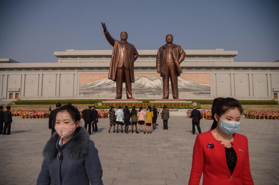 People wearing face masks leave after laying flowers before the statues of late North Korean leaders Kim Il Sung and Kim Jong Il on the occasion of the 108th birthday of late North Korean leader Kim Il Sung in Pyongyang on April 15, 2020. (Photo: Kim Won/AFP via Getty Images)