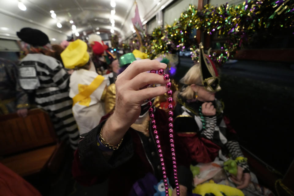 Members of the Mardi Gras group The Phunny Phorty Phellows prepare to hand out beads as they revel on a street car for their annual kick off of the Mardi Gras season on Twelfth Night in New Orleans, Friday, Jan. 6, 2023. (AP Photo/Gerald Herbert)