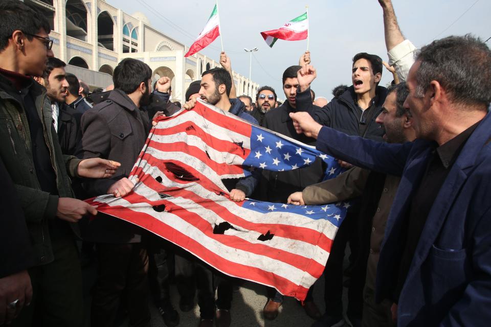 Iranians tear up an American flag during the protests. (Photo: ATTA KENARE via Getty Images)