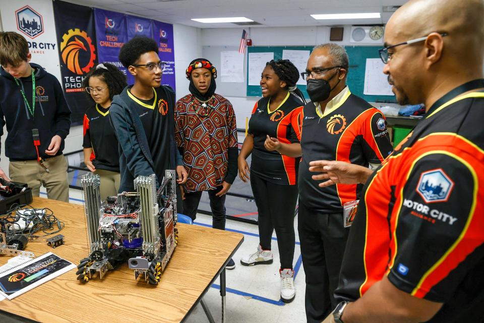 Aslan Fleming, 13, center, listens to his coaches, Jean-Claude Quenum and Leon Pryor, before the start of practice at the Foreign Language Immersion And Cultural Studies School in Detroit on Friday, Feb. 10, 2023. The team qualified for the world robotics championship that happens in Houston in April. It is the first Detroit middle school to compete in it.