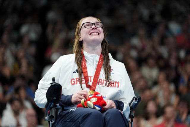 Brock Whiston looks up as she wears her gold medal during the ceremony