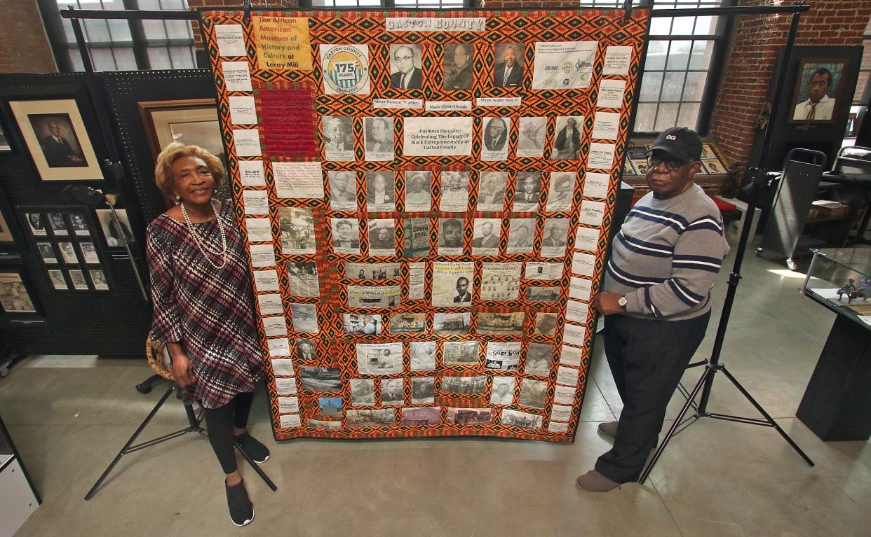 Dot Guthrie and Charles Whitesides stand next to the Gaston County Business Pioneers Quilt on display at the African American Museum of History & Culture at Loray Mill in Gastonia Tuesday afternoon, March 29, 2022.