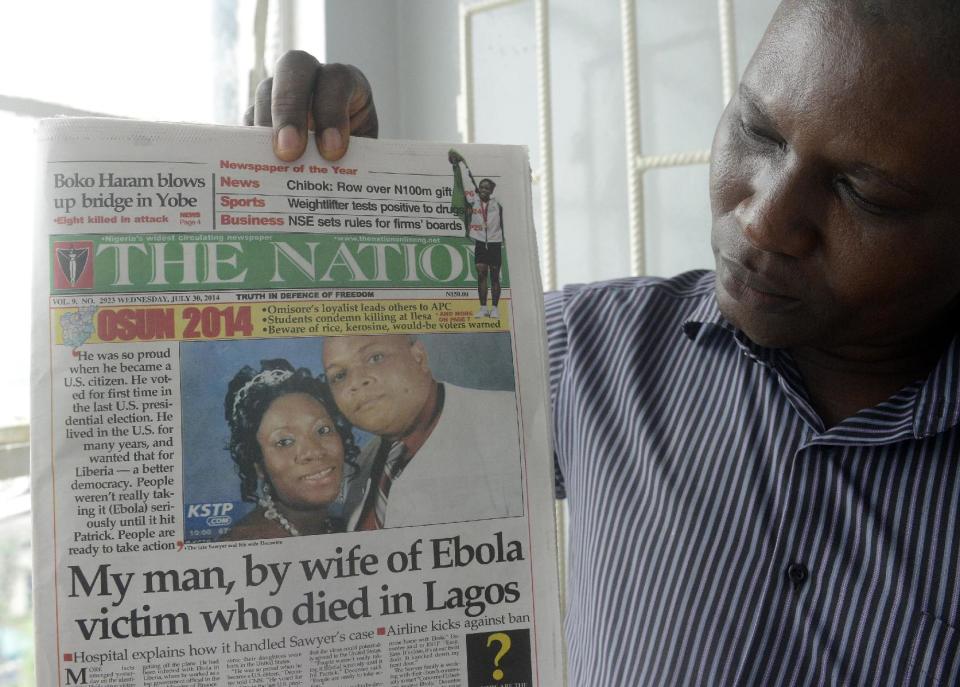 A man holds a newspaper featuring a story on the death of Patrick Sawyer on July 30, 2014. (Pius Utomi Ekpei/AFP)