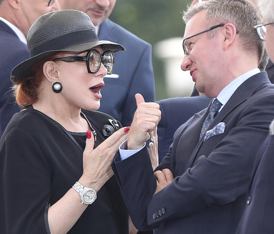 The U.S ambassador to Poland Georgette Mosbacher speaks with Krzysztof Szczerski, an advisor to Polish President Andrzej Duda during the annual Armed Forces review during a national holiday, in Katowice, Poland, Thursday, Aug. 15, 2019. Large crowds turned out for the celebration which this year included a fly-over by two U.S. F-15 fighter jets. (AP Photo/Czarek Sokolowski)