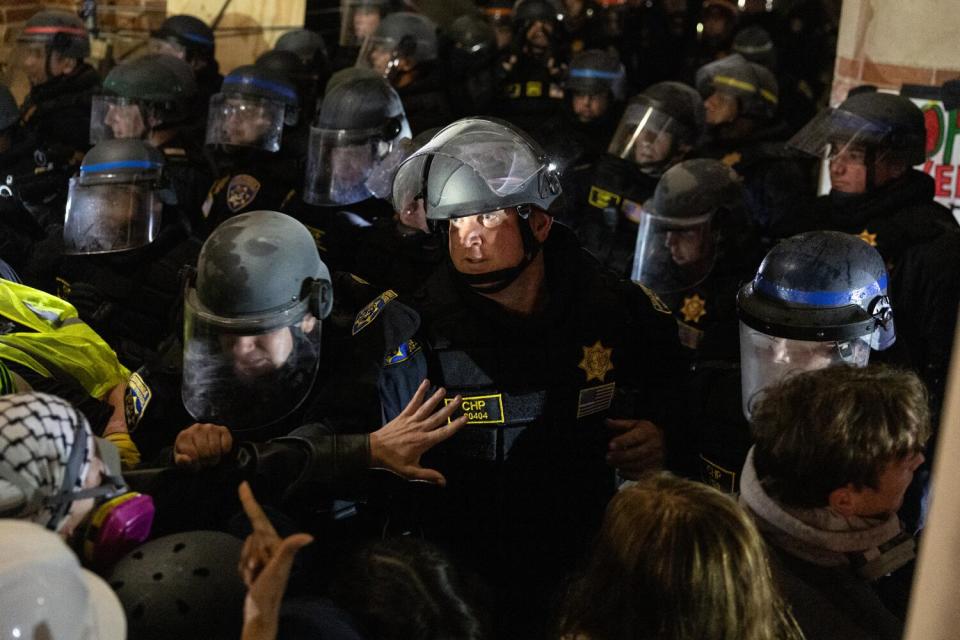 Pro-Palestinian demonstrators occupy an encampment at UCLA as authorities breach it.