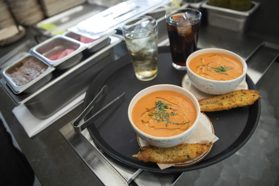 In this Tuesday, Nov. 26, 2019, photo shows appetizers and drinks ready to be served a the at the Bistro Verde restaurant at the Nordstrom NYC Flagship in New York. Luxury department stores like Neiman Marcus and Saks Fifth Avenue once ruled among the affluent set. Now, they’re fighting a tough battle to lure younger shoppers faced with a lot more shopping choices, including second-hand retailers and fashion rental companies. (AP Photo/Mary Altaffer)