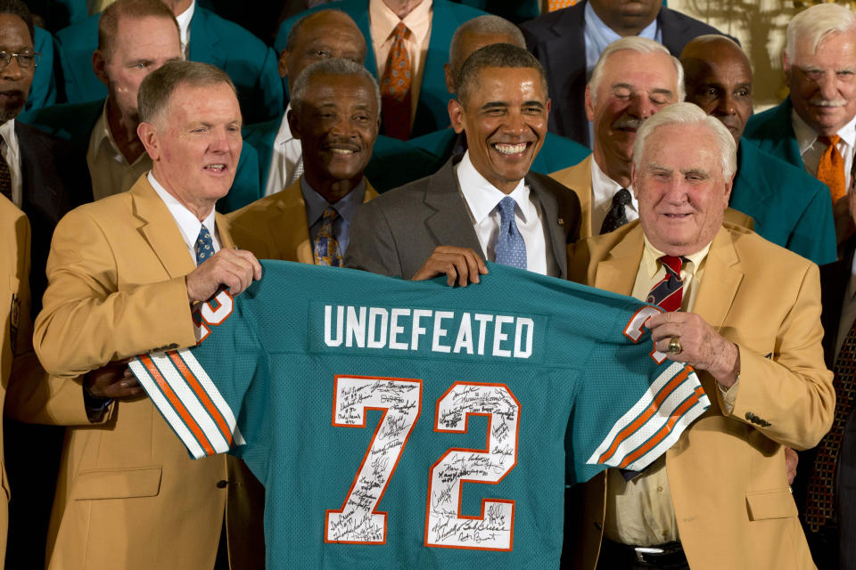 Former Miami Dolphins football quarterback Bob Griese, left, President Barack Obama and 1972 Dolphins Coach Don Shula, right, hold a signed jersey in the East Room of the White House in Washington, Tuesday, Aug. 20, 2013, during a ceremony honoring the Super Bowl VII football Champion Miami Dolphins. The 1972 Miami Dolphins remain the only undefeated team in NFL history. Form left are, Griese, wide receiver Paul Warfield, the president, running back Larry Csonka and Shula. (AP Photo/Jacquelyn Martin)