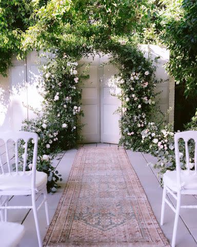 <p>Kat Dennings/Instagram</p> Kat Dennings shows off the completed white-rose arch for her wedding day.