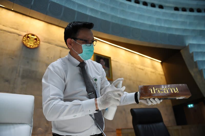 An employee cleans a chair at the parliament, where according to local media a member attended a session after an unreported trip to Japan and the building had to be cleaned, in Bangkok