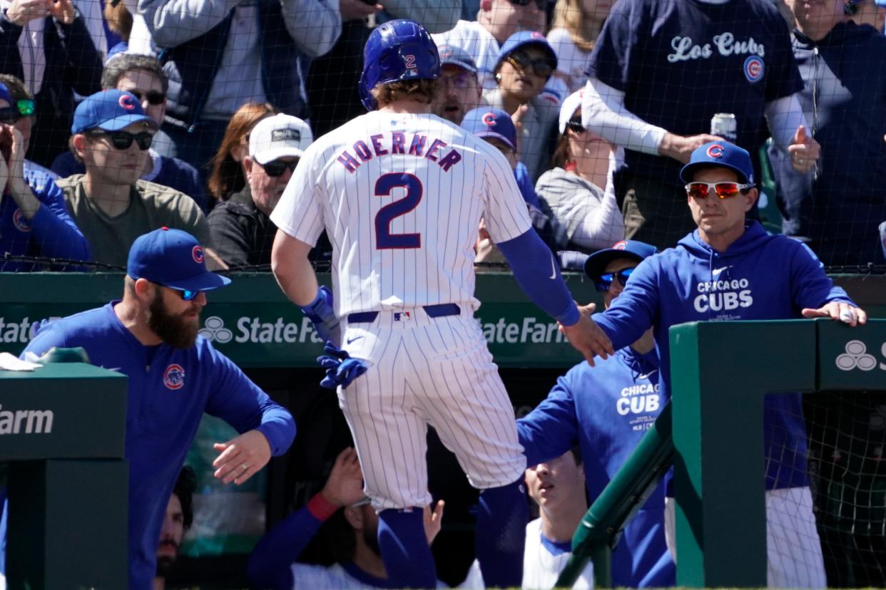 Cubs second base Nico Hoerner is greeted by manager Craig Counsell (right) after scoring on a wild pitch against the Milwaukee Brewers during the fifth inning Sunday at Wrigley Field.
