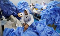 A man sews coats in a factory that produces sterilised surgical equipment and medical clothings in Egypt