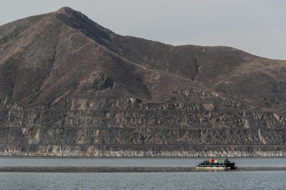 A lake in front of a hill.