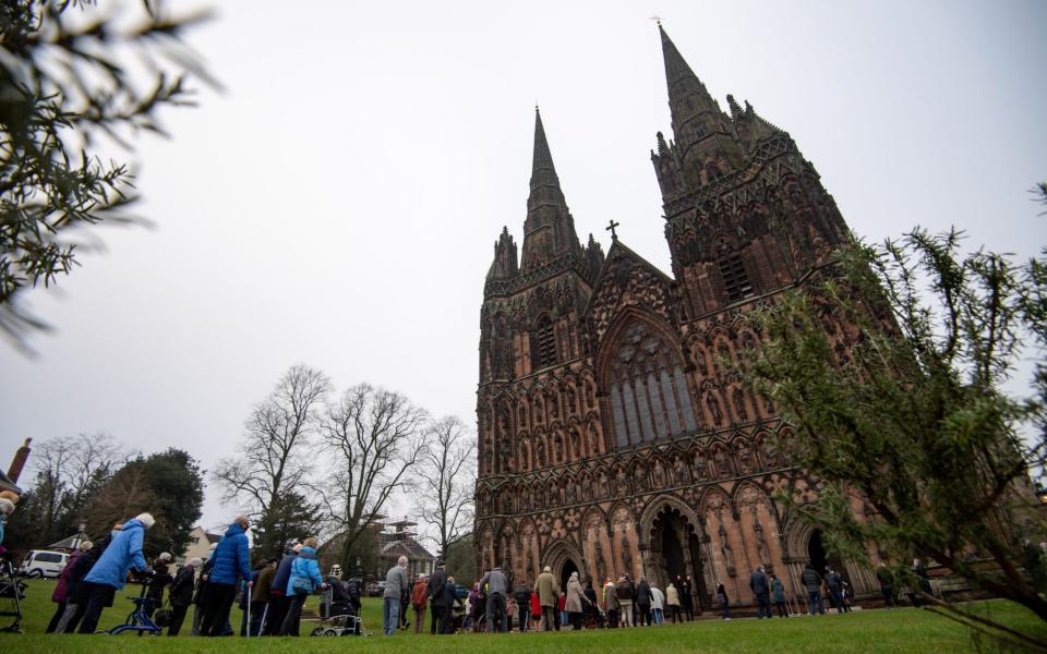 Members of the public queue outside Lichfield Cathedral, Staffordshire, to receive an injection of the Oxford vaccine - Jacob King/ PA