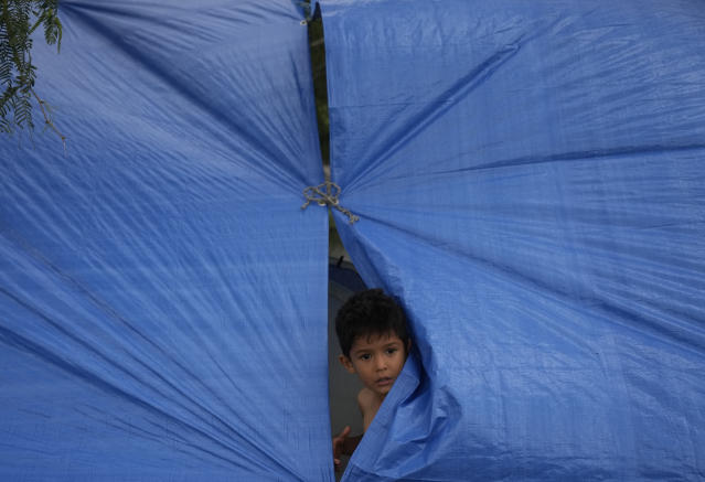A Venezuelan migrant child looks out from a makeshift tent, constructed by his parents on the the banks of the Rio Grande in Matamoros, Mexico, Friday, May 12, 2023, a day after pandemic-related asylum restrictions called Title 42 were lifted. (AP Photo/Fernando Llano)