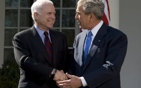John McCain shakes hands with George W. Bush in 2008 after recieving his endorsement as the Republican presidential nominee in the Rose Garden of the White House in Washington, DC - Credit:  JIM WATSON/AFP