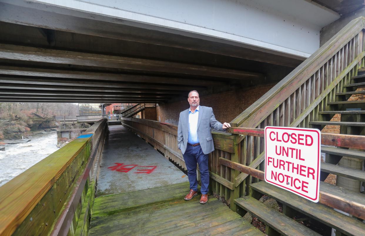 Jeff Lynch, general manager of the Sheraton Suites on Front Street stands at a closed section of the Boardwalk that runs under Broad Boulevard to the Jetty, the Cuyahoga Falls hotel's popular outdoor bar.  ARPA funds will go towards redesigning and rebuilding the boardwalk.
