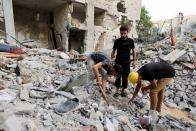 Palestinians gather at the scene where senior commander of Islamic Jihad militant group Khaled Mansour was killed in Israeli strikes, in Rafah