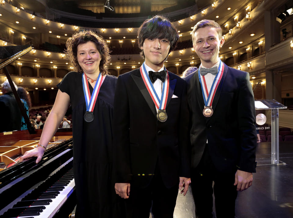 In this photo provided by The Cliburn, the winners of the 16th Van Cliburn International Piano Competition, silver medalist Anne Geniushene, left, from Russia, gold medalist Yunchan Lim, from South Korea, and bronze medalist Dmytro Choni, from Ukraine pose for a group photo Saturday, June 18, 2022, following the final concerts at the Bass Performance Hall in Fort Worth, Texas. (Ralph Lauer/The Cliburn via AP)