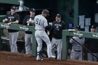 New York Yankees' Oswald Peraza (91) celebrates his solo home run with manager Aaron Boone, center right, in the second inning of the first baseball game of a doubleheader against the Texas Rangers in Arlington, Texas, Tuesday, Oct. 4, 2022. (AP Photo/Tony Gutierrez)