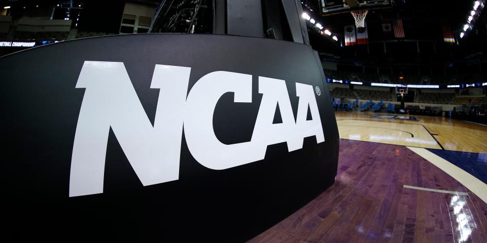 The NCAA logo on a basketball court.