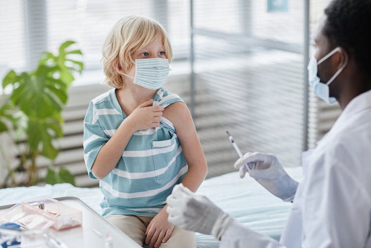 A young boy prepares to receive a vaccination.