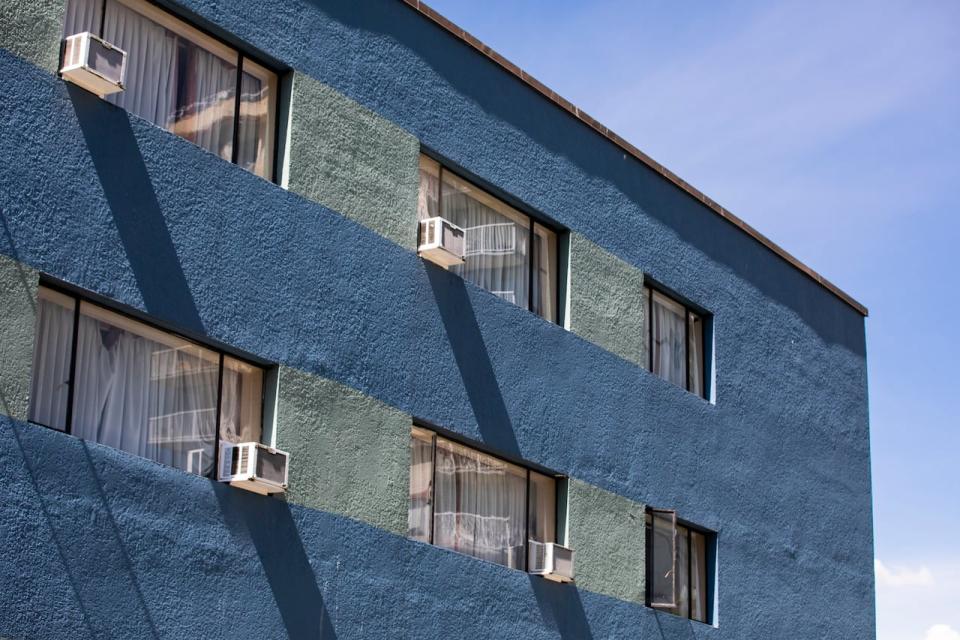 Air conditioners in the windows of English Bay Hotel in the West End of Vancouver.