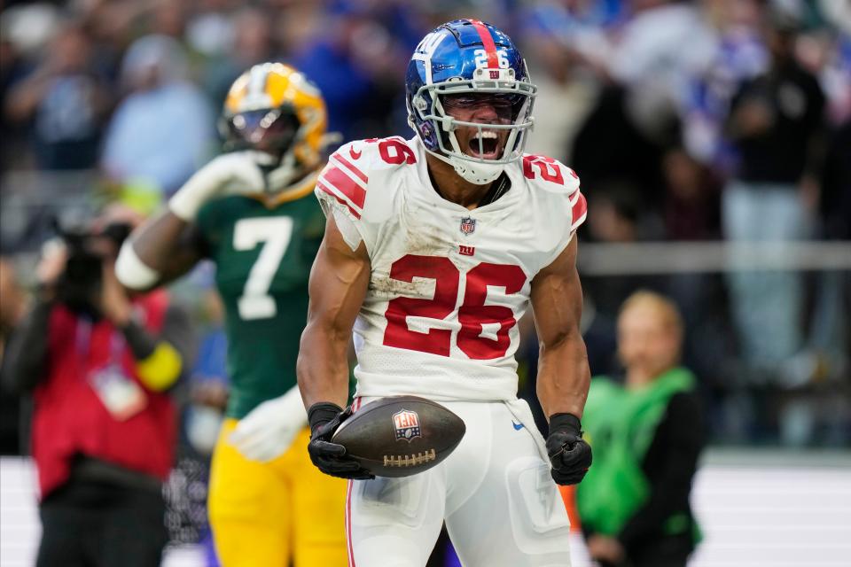 New York Giants running back Saquon Barkley (26) celebrates a touchdown during the second half of an NFL football game against the Green Bay Packers at the Tottenham Hotspur stadium in London, Sunday, Oct. 9, 2022.