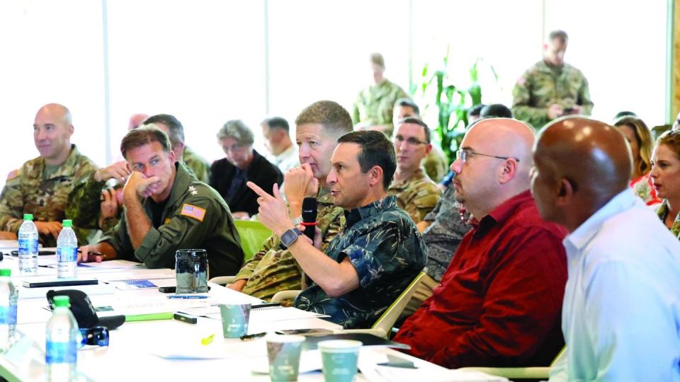 Doug Beck, who leads the Pentagon's Defense Innovation Unit, speaks into a microphone during the Dragon’s Lair competition focused on finding news ways to advance the military. (National Security Innovation Network)