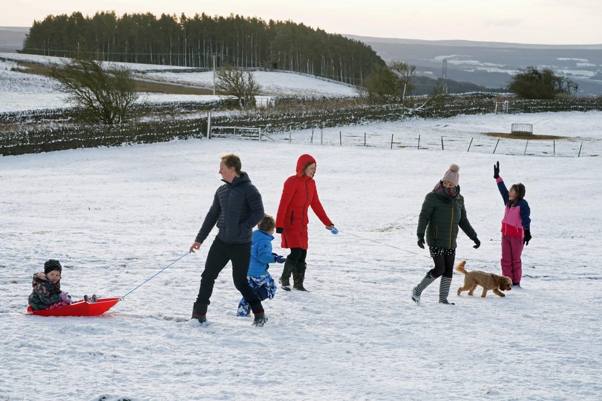 A family take advantage of the Christmas Day snow with a trip out sledging on the hills near Hexham, Northumberland (PA)