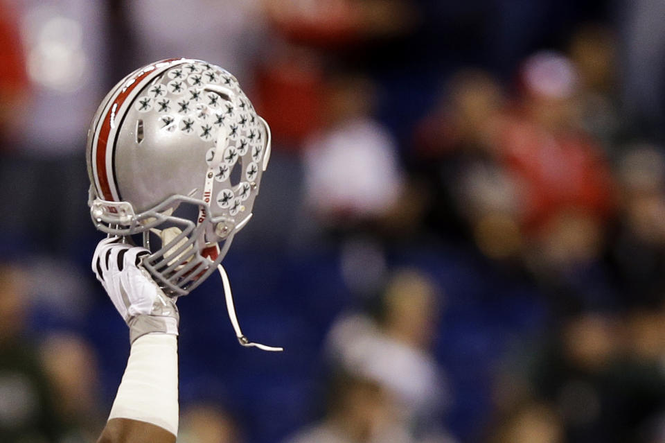 An Ohio State helmet is hoisted above the team as they prepare for the Big Ten Conference championship NCAA college football game against Michigan State, Saturday, Dec. 7, 2013, in Indianapolis. (AP Photo/Michael Conroy)