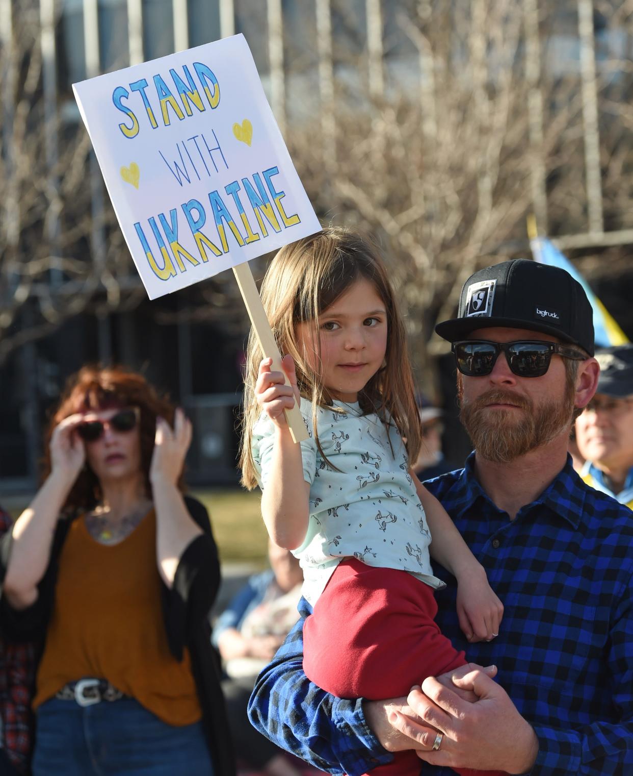 Adam Janecka holds his daughter, Ivena, 7, as they show their support at the "Stand with Ukraine" solidarity event on Tuesday, March 1, 2022, at City Plaza in downtown Reno.