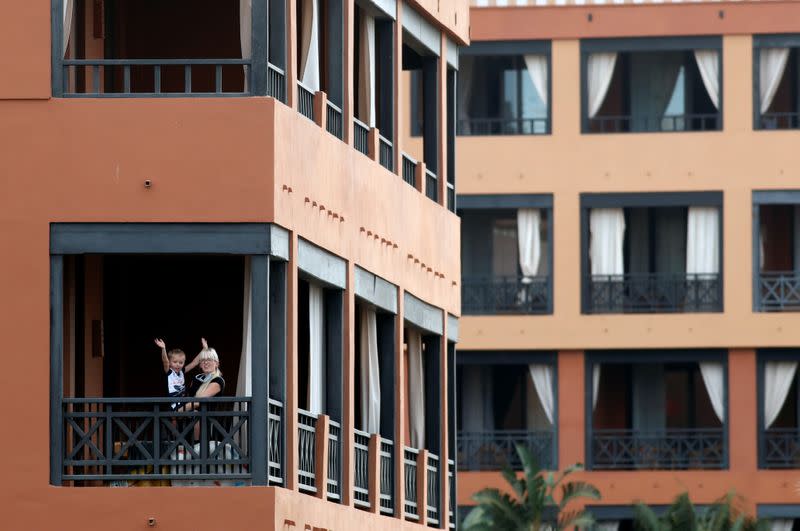 Una mujer juega con un niño en la terraza del hotel en el H10 Costa Adeje Palace, que está cerrado después de que se haya confirmado la existencia de un nuevo coronavirus en Adeje, en la isla española de Tenerife, España