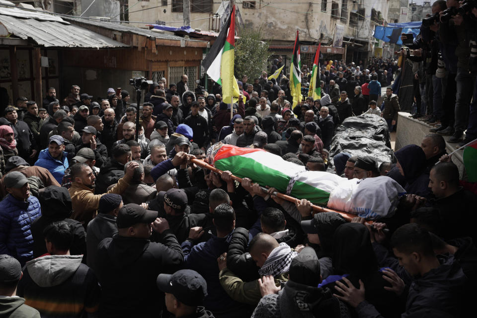 Palestinian mourners carry the body of Nader Rayan, 16, who was killed by Israeli forces during a raid at Balata refugee camp during his funeral in the Balata refugee camp near the West Bank city of Nablus, Tuesday, March 15, 2022. (AP Photo/Majdi Mohammed)