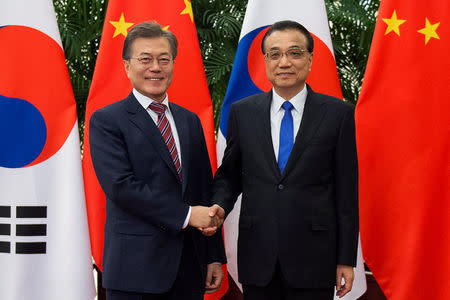 South Korea's President Moon Jae-In (L) shakes hands with China's Premier Li Keqiang (R) at the Great Hall of the People in Beijing, China December 15, 2017. REUTERS/Nicolas Asfouri/Pool