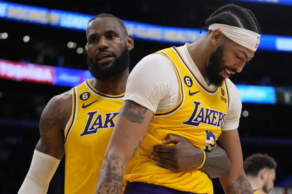 LeBron James, de los Lakers de Los Ángeles, abraza a su compañero Anthony Davis en el sexto partido de la semifinal de la Conferencia Oeste ante los Warriors de Golden State, el viernes 12 de mayo de 2023 (AP Foto/Ashley Landis)