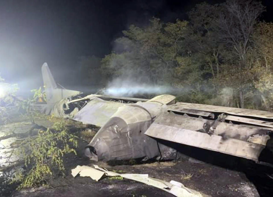 In this photo released by Kharkiv Regional State Administration, wreckage of an AN-26 military plane seen after it crashed in the town of Chuguyiv close to Kharkiv, Ukraine, late Friday, Sept. 25, 2020. A Ukrainian military plane carrying students at an aviation school crashed and burst into flames while landing, killing more than twenty people. Two other people on board were seriously injured and four people were missing. (Kharkiv Regional State Administration via AP)