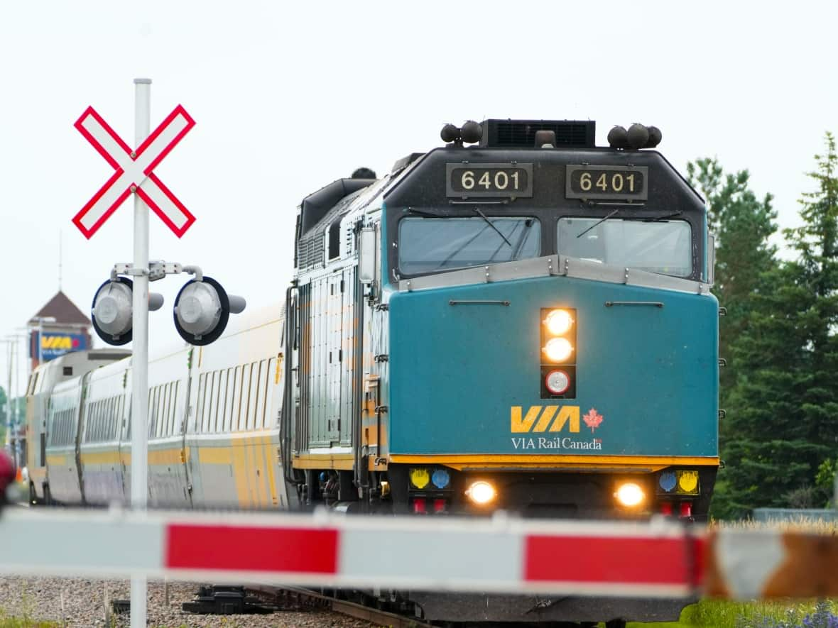 A Via Rail passenger train makes its way along the tracks in Ottawa on Monday. Unifor, which represents 2,400 employees at Via, said a tentative agreement was reached with the company just hours before members were prepared to strike. (Sean Kilpatrick/The Canadian Press - image credit)