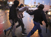 Police detain a demonstrator during an opposition rally to protest the official presidential election results in Minsk, Belarus, Sunday, Sept. 27, 2020. Tens of thousands of demonstrators marched in the Belarusian capital calling for the authoritarian president's ouster, some wearing cardboard crowns to ridicule him, on Sunday as the protests that have rocked the country marked their 50th consecutive day. (AP Photo/TUT.by)