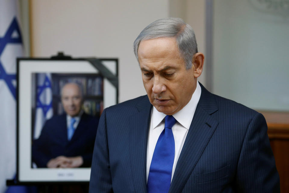 <p>Israeli Prime Minister Benjamin Netanyahu observes a moment of silence as he stands next to a photograph of former Israeli President Shimon Peres at the start of a special cabinet meeting to mourn the death of Peres, in Jerusalem on Sept. 28, 2016. (Photo: Ronen Zvulun/Reuters) </p>