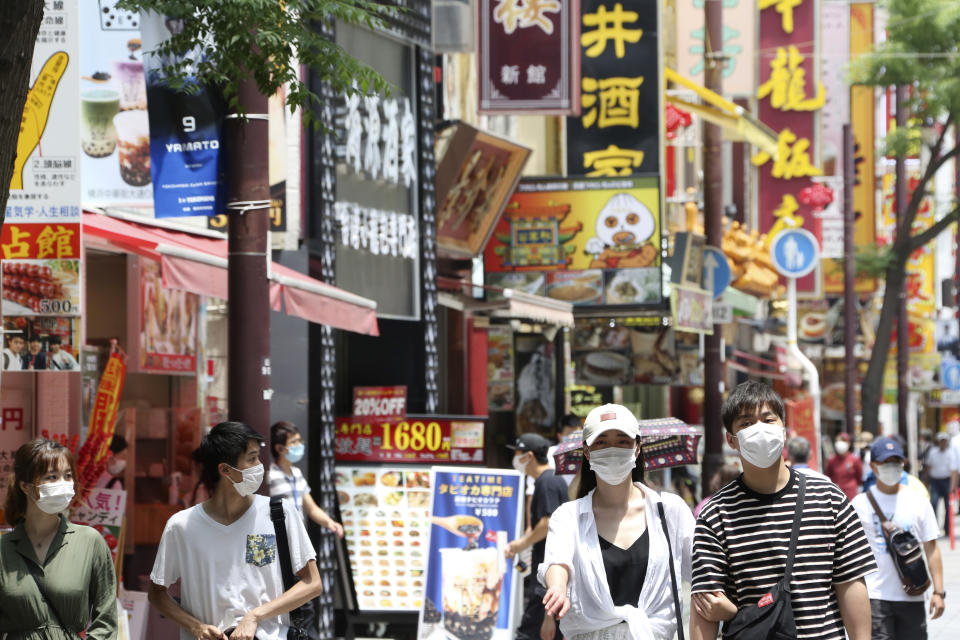 People wearing face masks to protect against the spread of the new coronavirus walk through China Town in Yokohama, near Tokyo, Wednesday, June 3, 2020. A coronavirus state of emergency was lifted, ending the restrictions nationwide as businesses began to reopen. (AP Photo/Koji Sasahara)