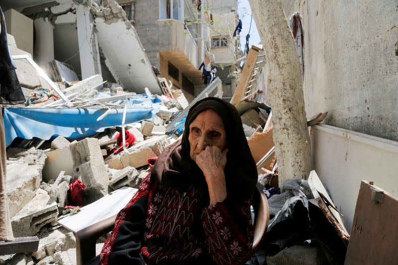 Palestinian woman, who forced to flee during the 'Nakba', sits in front of the rubble of her house in Gaza City