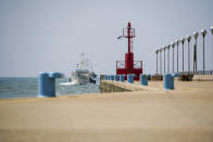 A fishing boat enters Fiumicino fishing port, on the outskirts of Rome Monday, March 30, 2020. Italy’s fishermen still go out to sea at night, but not as frequently in recent weeks since demand is down amid the country's devastating coronavirus outbreak. On Sundays, or any sunny day throughout the year, you can find several people strolling along, but since the Italian government ordered a nationwide lockdown and shut restaurants and cafés to stop the spread of Covid-19, the area is deserted, and apart from the water rippling against the quay, it is silent. (AP Photo/Andrew Medichini)