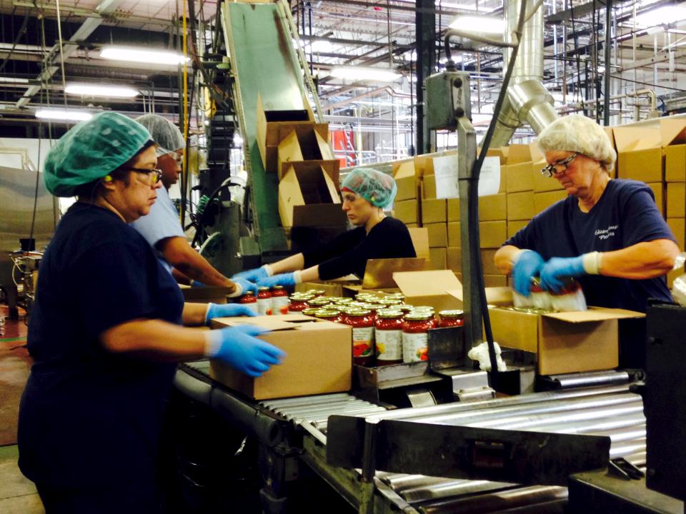 Workers box jars of pasta sauce at a plant run by Chelten House Products in Bridgeport, New Jersey July 27, 2015. The company produces private-label sauces, salsas and salad dressings for grocers such as Kroger, Whole Foods and Trader Joe's. As the Federal Reserve puzzles over what is holding back U.S. wages and productivity six years into the economic recovery, a pasta sauce company in New Jersey may offer some answers. Picture taken July 27, 2015. To match Insight USA-ECONOMY/LABOR REUTERS/Jonathan Spicer