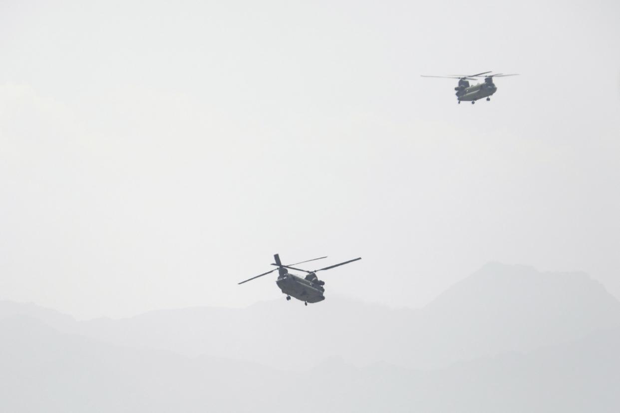 U.S. Chinook helicopters fly over the city of Kabul, Afghanistan on Sunday, Aug. 15, 2021. Helicopters are landing at the U.S. Embassy in Kabul as diplomatic vehicles leave the compound amid the Taliban advanced on the Afghan capital.
