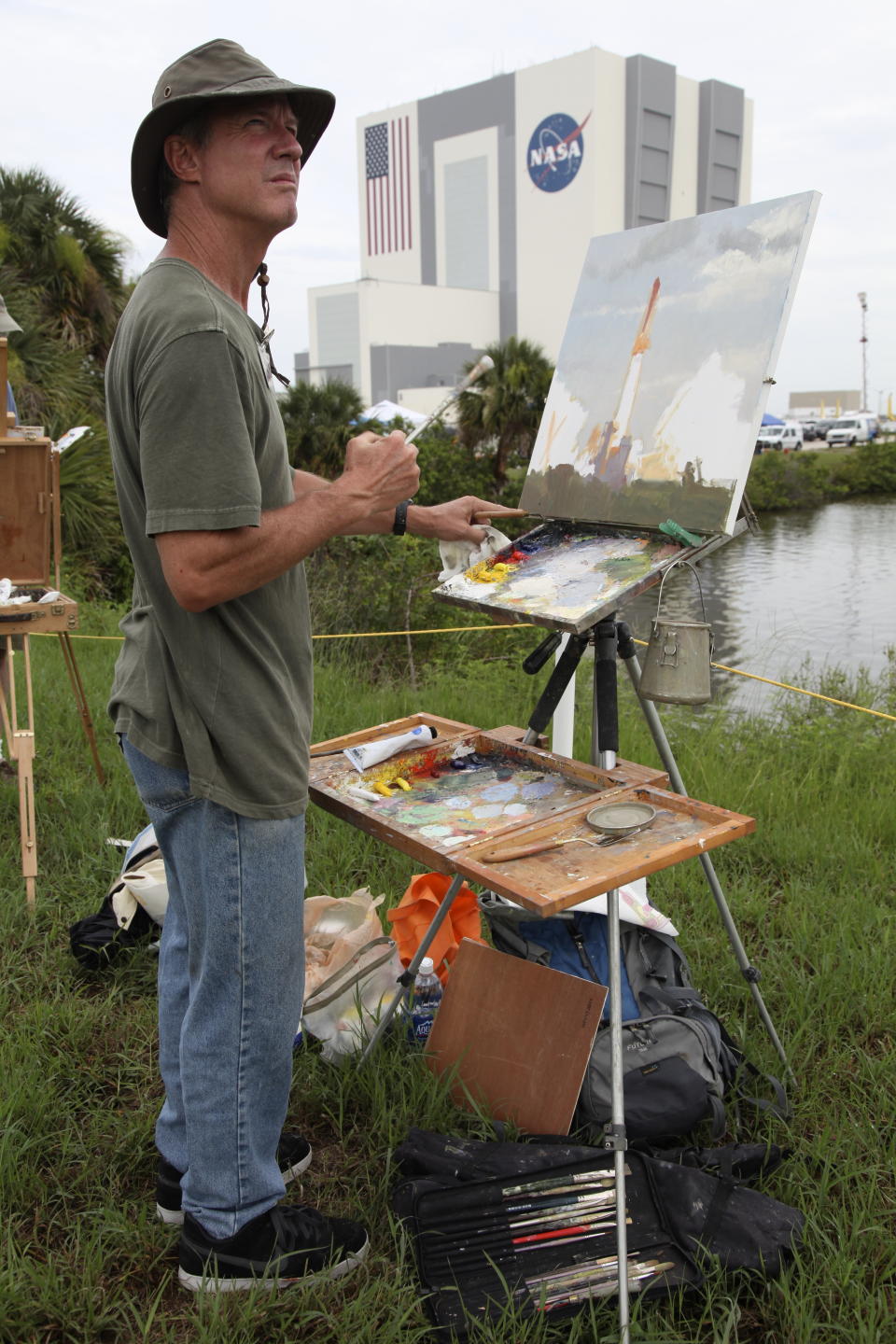 FILE - In this Friday, July 8, 2011 file photo, artist Larry Moore paints the scene at the Kennedy Space Center in Cape Canaveral, Fla., during the launch of the Atlantis, the 135th and final space shuttle mission for U.S. (AP Photo/Robert Ray)