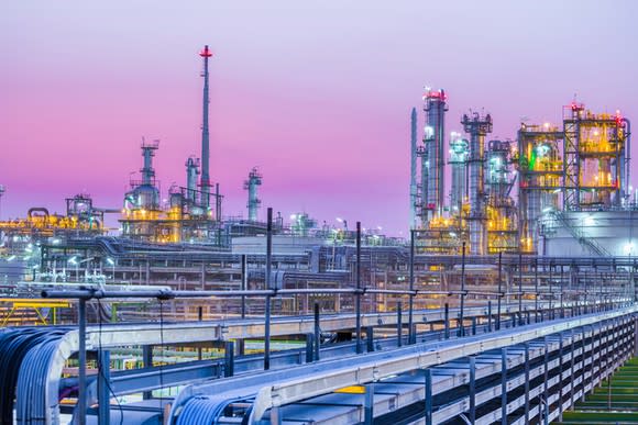 An oil refinery with a pink sky in the backdrop