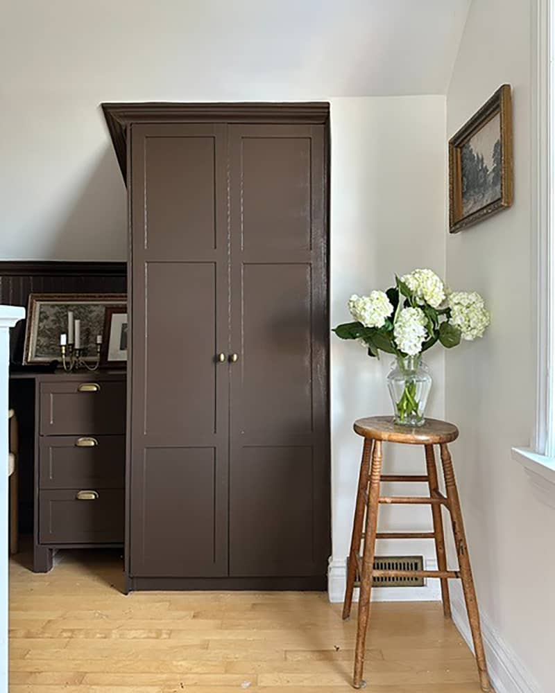 Floral arrangement on stool in hallway.